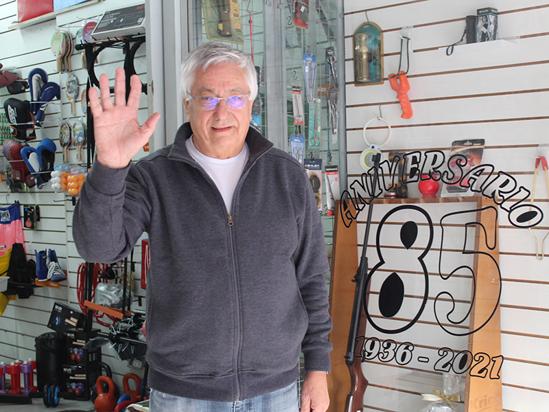 Alberto momenech saludando a cámara, en la puerta de su local