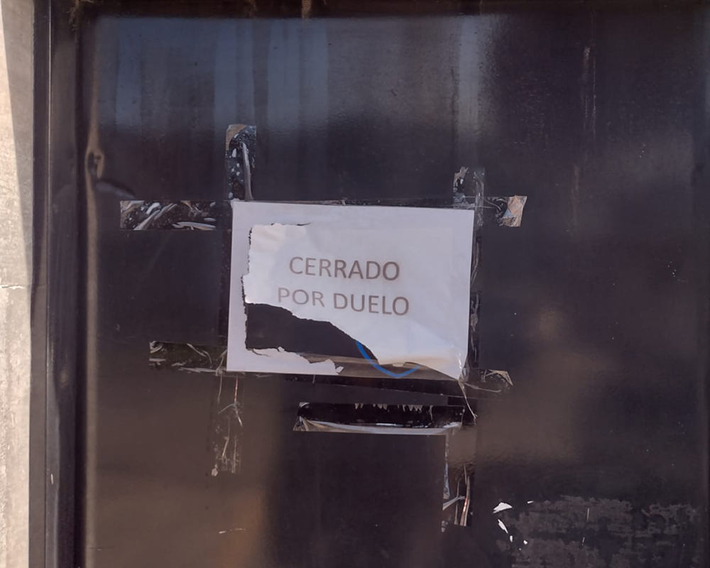 cartel de "Cerrado por duelo" en la puerta del local de EW Automotores