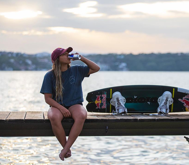 eugenia de armas sentada en un muelle tomando red bull